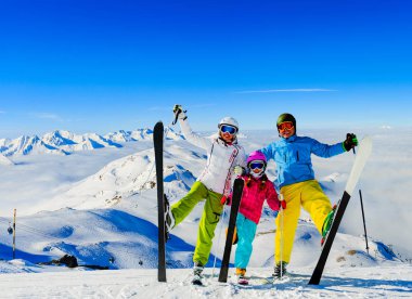 Dağlarda kış tatillerinin tadını çıkaran mutlu aile, Val Thorens