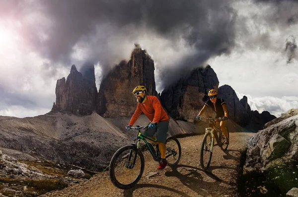 Couple cycling on electric bike, rides mountain trail. Woman and