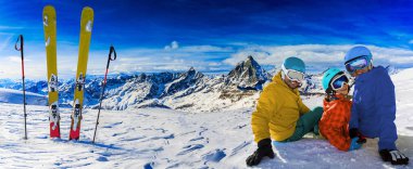 Kış mevsiminde kayak, dağlar ve güneşli havada kayak ailesi. 