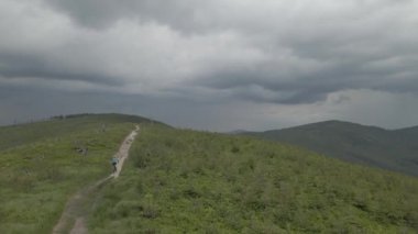 Yaz dağları manzarasında bisikletli bir kadının hava görüntüsü. MTB kullanan kadın.