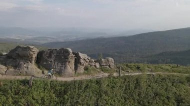 Yaz dağları manzarasında bisikletli bir kadının hava görüntüsü. MTB kullanan kadın.