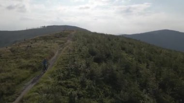 Yaz dağları manzarasında bisikletli bir kadının hava görüntüsü. MTB kullanan kadın.