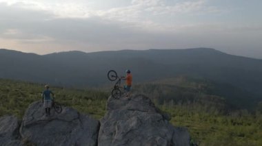 Yaz dağları manzarasında bisiklete binen çiftlerin hava görüntüleri. MTB 'de erkek ve kadın açık hava macerası..