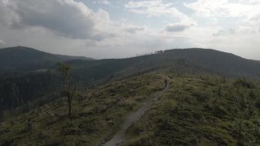 Yaz dağları manzarasında bisikletli bir kadının hava görüntüsü. MTB kullanan kadın.