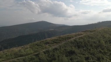 Yaz dağları manzarasında bisikletli bir kadının hava görüntüsü. MTB kullanan kadın.