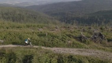 Yaz dağları manzarasında bisikletli bir kadının hava görüntüsü. MTB kullanan kadın.