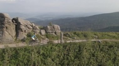 Yaz dağları manzarasında bisikletli bir kadının hava görüntüsü. MTB kullanan kadın.