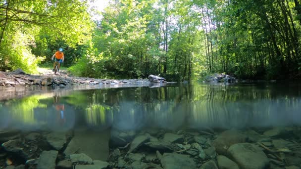 Человек Велосипеде Пересекает Горную Реку Брызгами Воды Медленного Движения Человек — стоковое видео