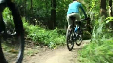 Bisikletli kadın ve erkekler günbatımı dağ manzarasında bisiklet sürüyorlar. Birkaç bisiklet MTB enduro akış yolu. Açık hava sporları aktivitesi.