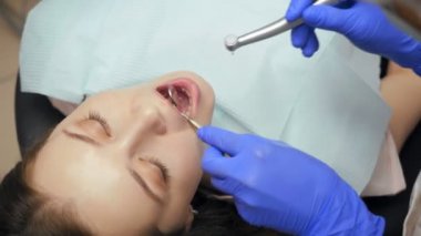 Kadın dişçi diş kliniği genç kadın hastada tedavi.
