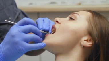 Erkek diş hekimi diş kliniği genç kadın hastada tedavi. Diş işaretleyiniz.