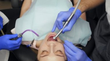 Klinikte dişlerini tedavi eden erkek dişçi..