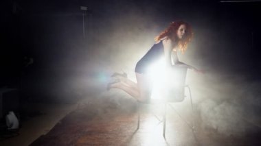 Sandalyeyle dans cinsel esnek Kızıl saçlı kadın.