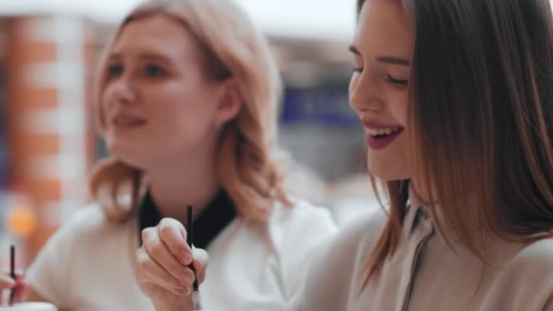 Two young women talking and drinking coffee sitting in cafe. — Stock Video