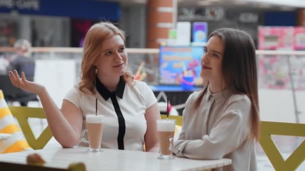 Mujeres jóvenes tomando café y comunicándose en la cafetería . — Vídeo de stock