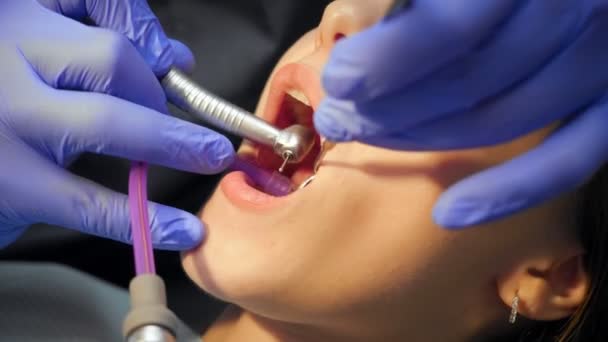 Muž zubař léčení zuby na mladou ženu pacienta na klinice.