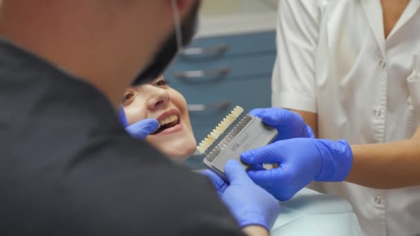 Dentista masculino tratando dentes para jovem paciente na clínica . — Vídeo de Stock