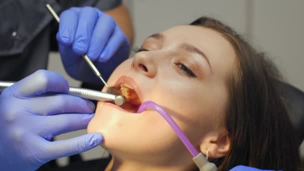 Dentista masculino tratando dentes para jovem paciente na clínica . — Vídeo de Stock