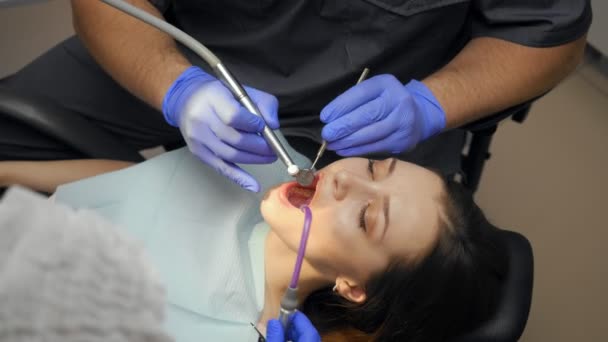Odontoiatra di sesso maschile che cura i denti alla giovane paziente in clinica . — Video Stock