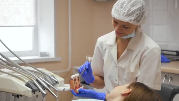 Dentista donna che cura i denti a una giovane paziente in clinica . — Video Stock