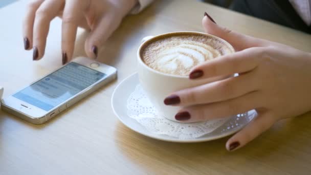 Frau nutzt Smartphone in Kaffeepause. — Stockvideo