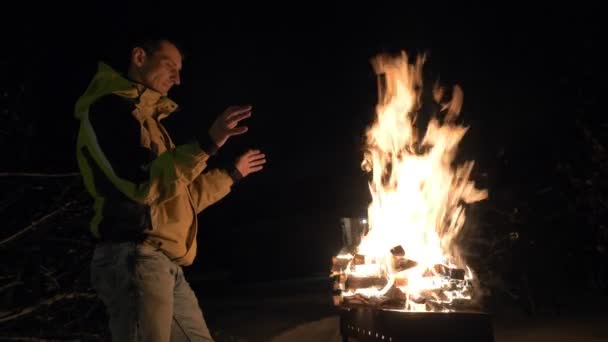 Homme près de brasero avec le feu et chauffe ses mains en hiver . — Video