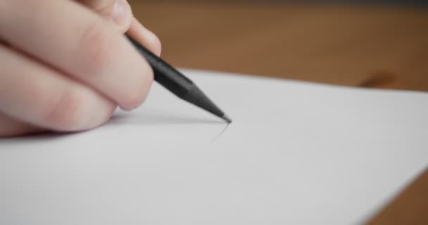 Kleine hand tekenen op blanco papier met een potlood. — Stockvideo