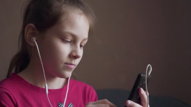 Young girl listening to music from earings and feeling rhythm. — Stock Video