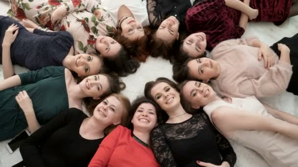 Вид сверху на счастливых женщин в платьях, лежащих на полу . — стоковое видео