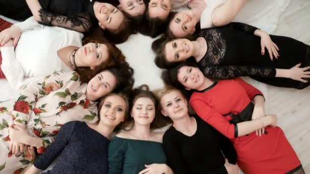 Вид сверху на счастливых женщин в платьях, лежащих на полу . — стоковое видео