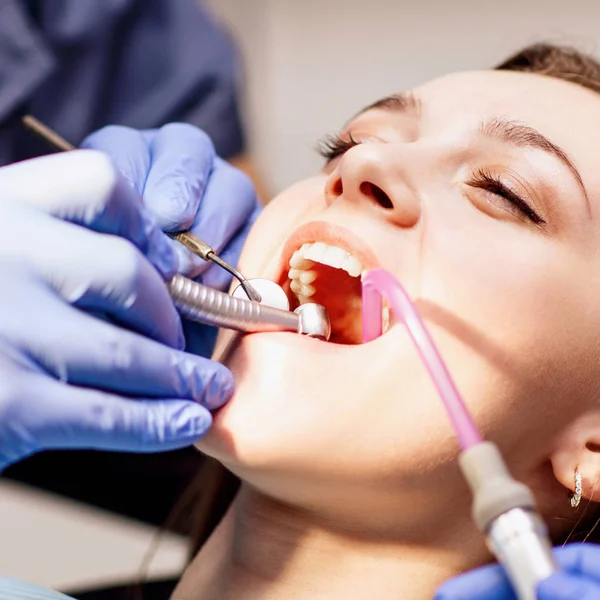 Klinikte dişlerini tedavi eden erkek dişçi..