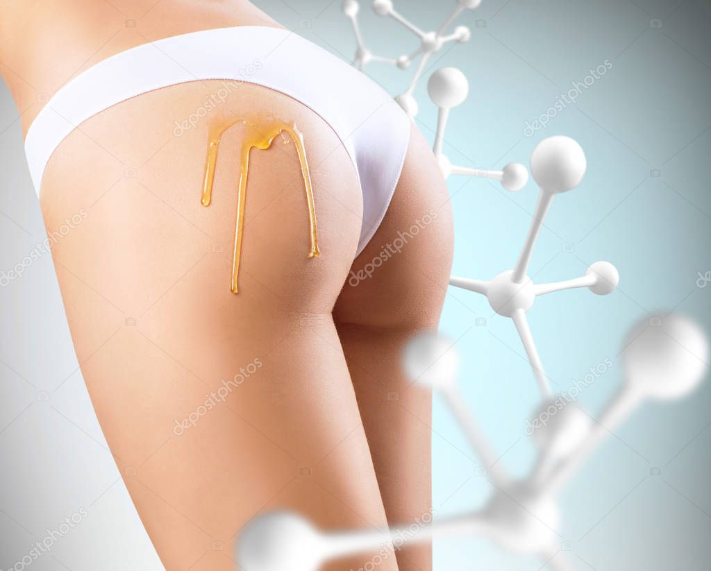 Cosmetics oil applying on sexy female buttocks near molecules.