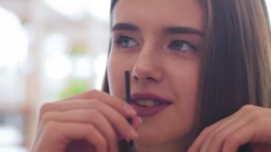 Kahve içme ve FRIEN Cafe ile konuşan genç kadın.