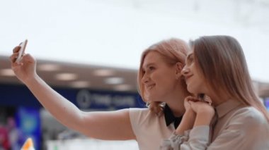 İki mutlu genç kadın selfie alışveriş merkezinde yapma.