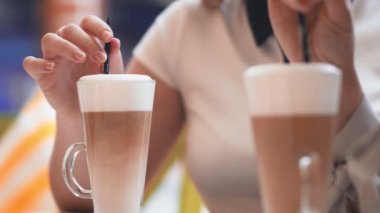 Kafede oturup kahve içen iki genç kadın..