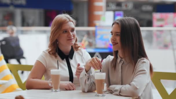 Молодые женщины пьют кофе и общаются в кафе . — стоковое видео