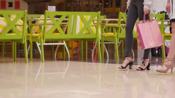 Jonge vrouwen lopen met aankopen in het winkelcentrum. — Stockvideo