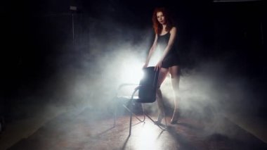 Sandalyeyle dans cinsel esnek Kızıl saçlı kadın.