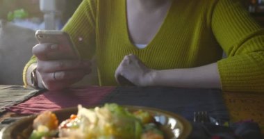 Beklerken smartphone kullanarak kafedeki kadına.