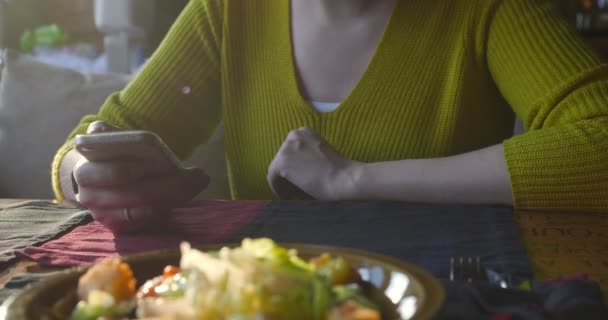 Mulher no café usando smartphone enquanto espera . — Vídeo de Stock