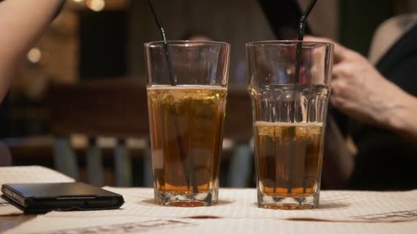 Zwei Glas Cocktails auf dem Tisch im Vordergrund. — Stockvideo