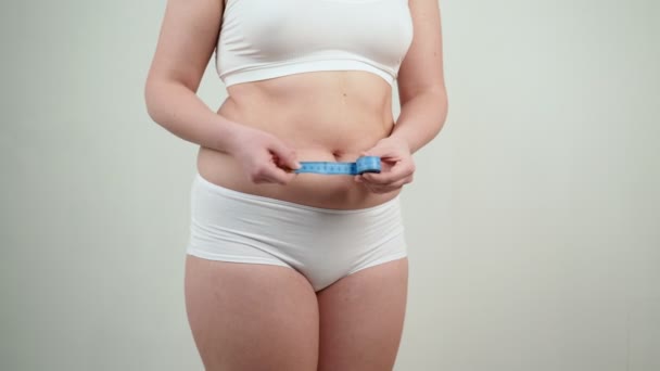 Mujer con sobrepeso midiendo su vientre gordo. — Vídeos de Stock