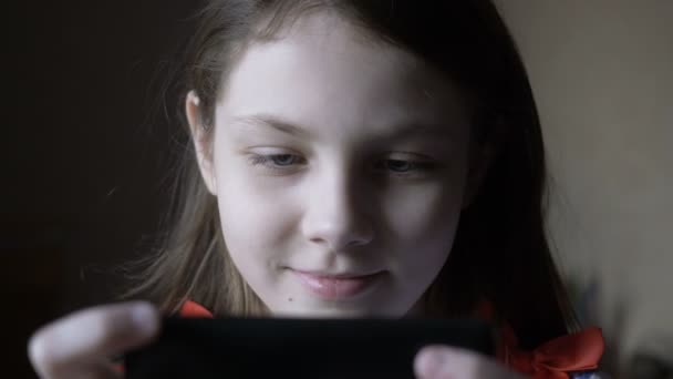 Niña jugando en el teléfono inteligente en casa . — Vídeo de stock