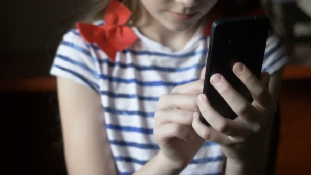 Sonriente chica mensaje de texto en el teléfono inteligente en casa . — Vídeo de stock