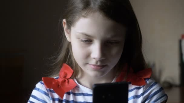 Uśmiechnięta dziewczyna wiadomość SMS-y na smartfonie w domu. — Wideo stockowe