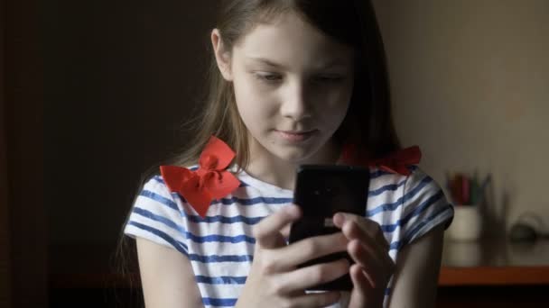 Sourire fille texto message sur smartphone à la maison . — Video