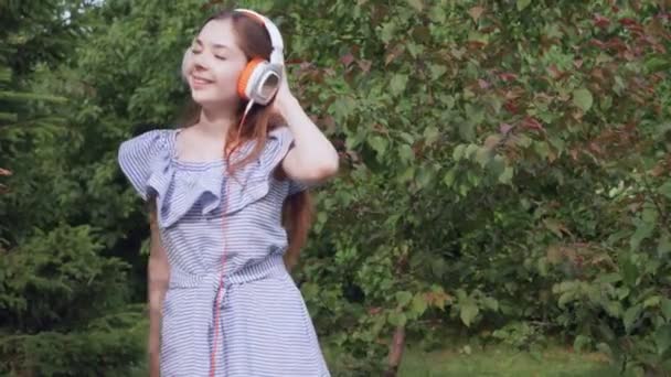 Молодая женщина с наушниками слушает музыку. — стоковое видео