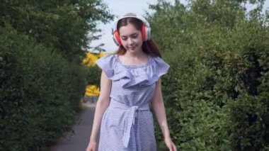 Kulaklıklı genç bir kadın müzik dinliyor..