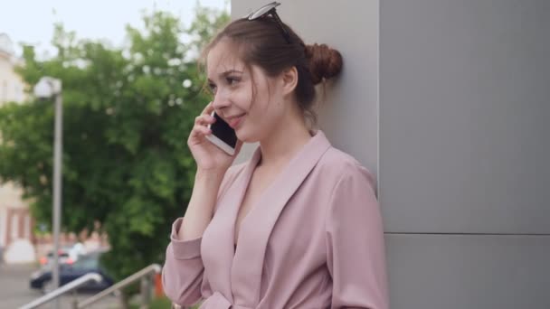 Mujer joven hablando en su teléfono celular en la calle . — Vídeos de Stock