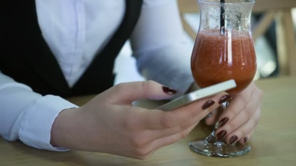 Kobieta za pomocą smartphone i picia koktajl. — Wideo stockowe